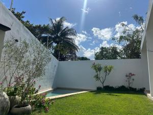 a backyard with a white fence and a lawn at Muunyal Naj in Valladolid