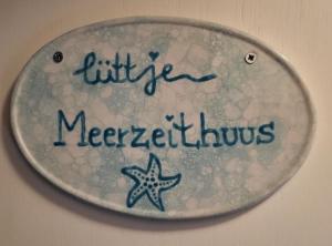 a sign with a starfish on a wall at lüttje Meerzeithuus in Carolinensiel