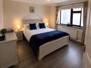 a bedroom with a large bed with blue pillows at Katie's Cottage in Laghy