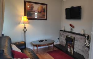 a living room with a couch and a fireplace at Katie's Cottage in Laghy