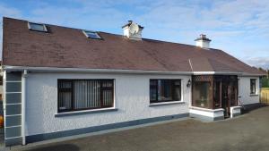 a white house with a brown roof at Katie's Cottage in Laghy