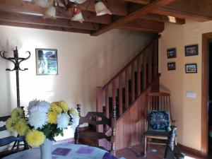 un comedor con una mesa con un jarrón de flores en Casa Rural Casa Azul, en Villahormes