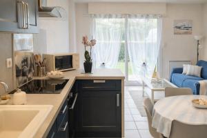 a kitchen and living room with a sink and a table at Centre ville de Sarzeau, appartement au calme avec jardinet et parking privé in Sarzeau