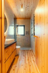 a bathroom with a sink and a toilet and wooden floors at Casa do Incenso in São Roque do Pico +54 photos