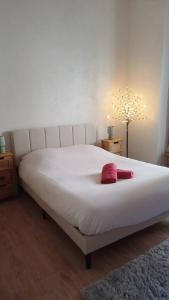 a large white bed with two red towels on it at Larbaud 6 - Hypercentre - Proche Thermes - Spacieux in Vichy