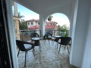 a balcony with chairs and tables on a balcony at Ocean Cliff Homes 4 bedroom shared apartment in Mombasa