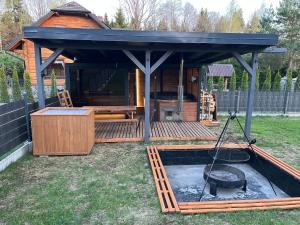 a gazebo with a grill in a yard at Wypoczynek KOPANICA in Kopanica
