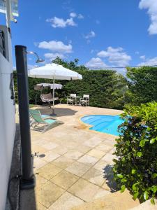 a patio with an umbrella and chairs and a pool at Villa Flash in Eantio +21 photos