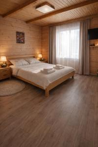 a bedroom with a large bed and a window at Гостинний двір in Vorokhta