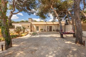 a house with a hammock hanging from two trees at Villa Fefè in Nardò