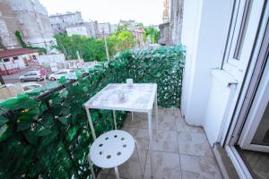 a small white table and chair on a balcony at The Bohemian Residence in Belgrade