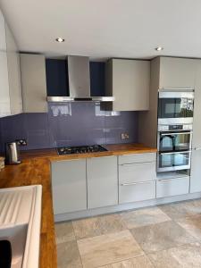 a kitchen with white cabinets and a stove top oven at Shepherds Barn in Beamish