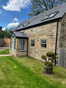 a stone house with a tree in a yard at Shepherds Barn in Beamish