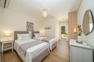 a hotel room with two beds and a mirror at Nefeli Duplex Apartment in Karavomylos