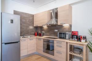a kitchen with wooden cabinets and a stainless steel refrigerator at Nefeli Duplex Apartment in Karavomylos