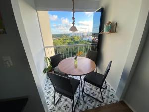 a table and chairs in a room with a balcony at Conforto e praticidade perto do aeroporto in Aracaju