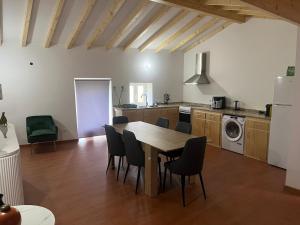 a kitchen with a table and chairs in a room at Casa do Rio Alva in Caldas de São Paulo