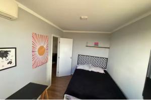a bedroom with a black bed in a room at Conforto e praticidade perto do aeroporto in Aracaju