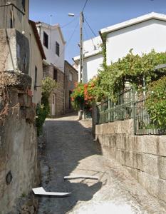 an alley with a stone wall and a building at Casa do Rio Alva in Caldas de São Paulo +16 photos