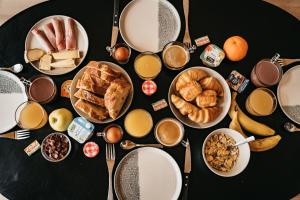 a black table topped with plates and bowls of breakfast foods at Les Terrasses du Grillon in Chambon-sur-Lac +66 photos