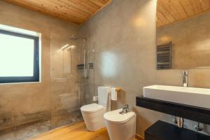a bathroom with a toilet and a sink and a shower at Casa da Rocha in Terra Alta +19 photos
