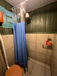 a bathroom with a blue shower curtain and a toilet at Pousada ilha das gamelas in Guaraqueçaba