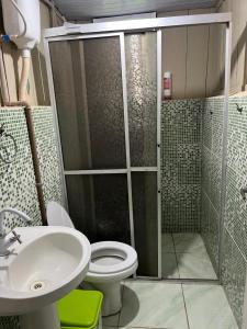 a bathroom with a shower and a toilet and a sink at Pousada ilha das gamelas in Guaraqueçaba