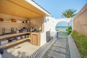 an outdoor kitchen with a view of the ocean at SunRise Beachfront Cha am in Ban Bang Ket