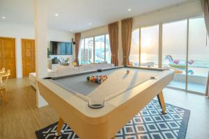 a pool table in a living room with a view of the ocean at SunRise Beachfront Cha am in Ban Bang Ket