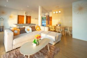 a living room with a white couch and a table at SunRise Beachfront Cha am in Ban Bang Ket +31 photos
