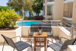 a balcony with chairs and a table and a pool at Nefeli Duplex Apartment in Karavomylos +43 photos