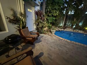 a patio with a chair and a swimming pool at Loft Style Apartment in Monte Vista +7 photos
