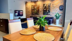 a dining room table with two chairs and a brick wall at Apartament Widna in Krakow