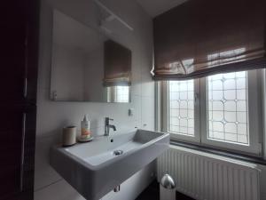 a white bathroom with a sink and a window at B&B Pied à Pieter in Maastricht +13 photos