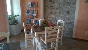 una mesa y sillas en una habitación con una pared de piedra en B&B Il Feriolo, en Baveno