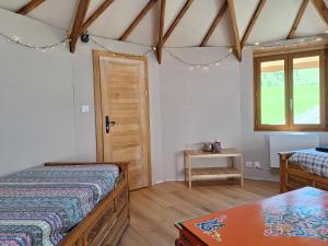 a bedroom with two beds and a table and a window at Le Repaire de Mitzerlé in Mitzach