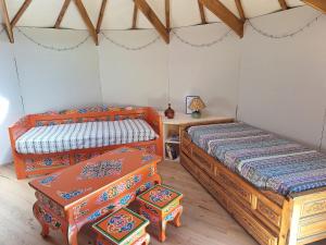 a bedroom with two beds and a table in a room at Le Repaire de Mitzerlé in Mitzach