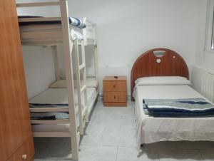 a bedroom with two bunk beds and a ladder at albergue bar villamayor in Villamayor del Río