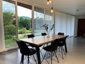 a dining room table with chairs and a large window at Креси in Yaremche