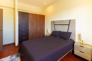 a bedroom with a bed with purple sheets and a cabinet at Santa Elena 400 in Torreón