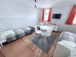 a bedroom with two beds and a table and chairs at U Marzeny in Malbork