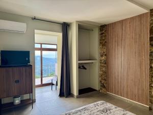 a living room with a television and a balcony at Residenza 33 in Torchiara
