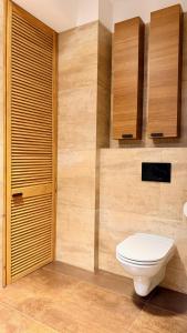 a bathroom with a white toilet and wooden cabinets at Apartament Widna in Krakow +12 photos