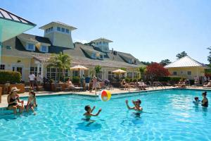 a group of people playing with a beach ball in a swimming pool at Glen Riddle 102 in Berlin