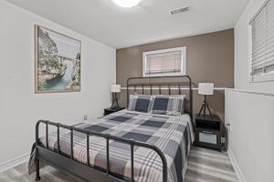 a bedroom with a bed and two windows at Entire 5 bedrooms House 14 guests in Barrie