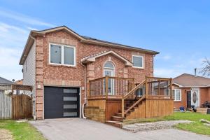 a brick house with a deck and a garage at Entire 5 bedrooms House 14 guests in Barrie