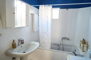 a white bathroom with a sink and a bath tub at Lagoon Dream in Fanari +28 photos