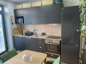a kitchen with gray cabinets and a sink and a table at Salina Ria Studio 2 in Aveiro