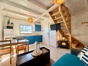 a kitchen and living room with a spiral staircase at CUBA domki letniskowe in Sarbinowo