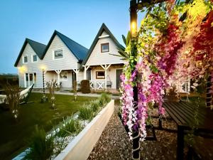 a house with flowers in the front yard at CUBA domki letniskowe in Sarbinowo